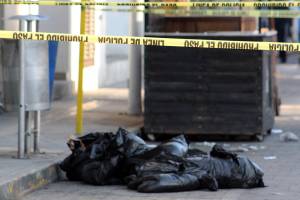 Hallan dos cadáveres embolsados con narcomensajes en el zócalo de Texmelucan