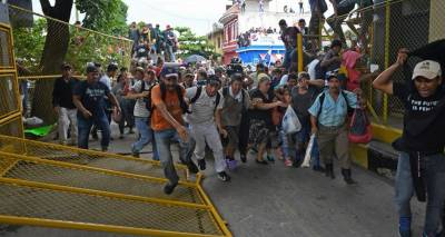 Caravana migrante da portazo en la frontera de México; dos policías heridos