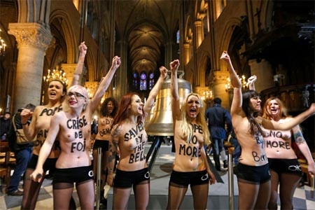 Mujeres en topples celebran renuncia de Benedicto XVI