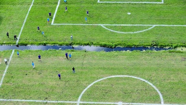 Holandeses juegan futbol en cancha dividida por río