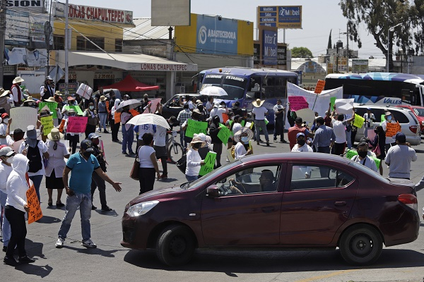 Locatarios del mercado de Amalucan se oponen a demolición y cierran entronque