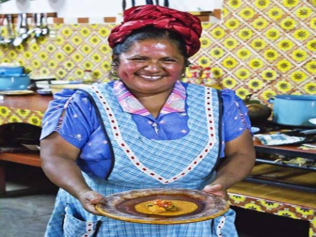 Señora con una vestimenta de mexico gran cocinera zapoteca con una gran sonrisa