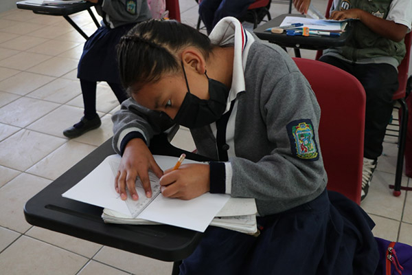 Niña en salón de Clases con uniforme Puebla