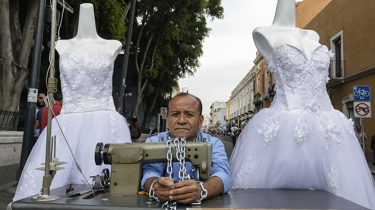 FOTOS: Clausuran su local, comerciante cierra calle y se encadena a máquina de coser