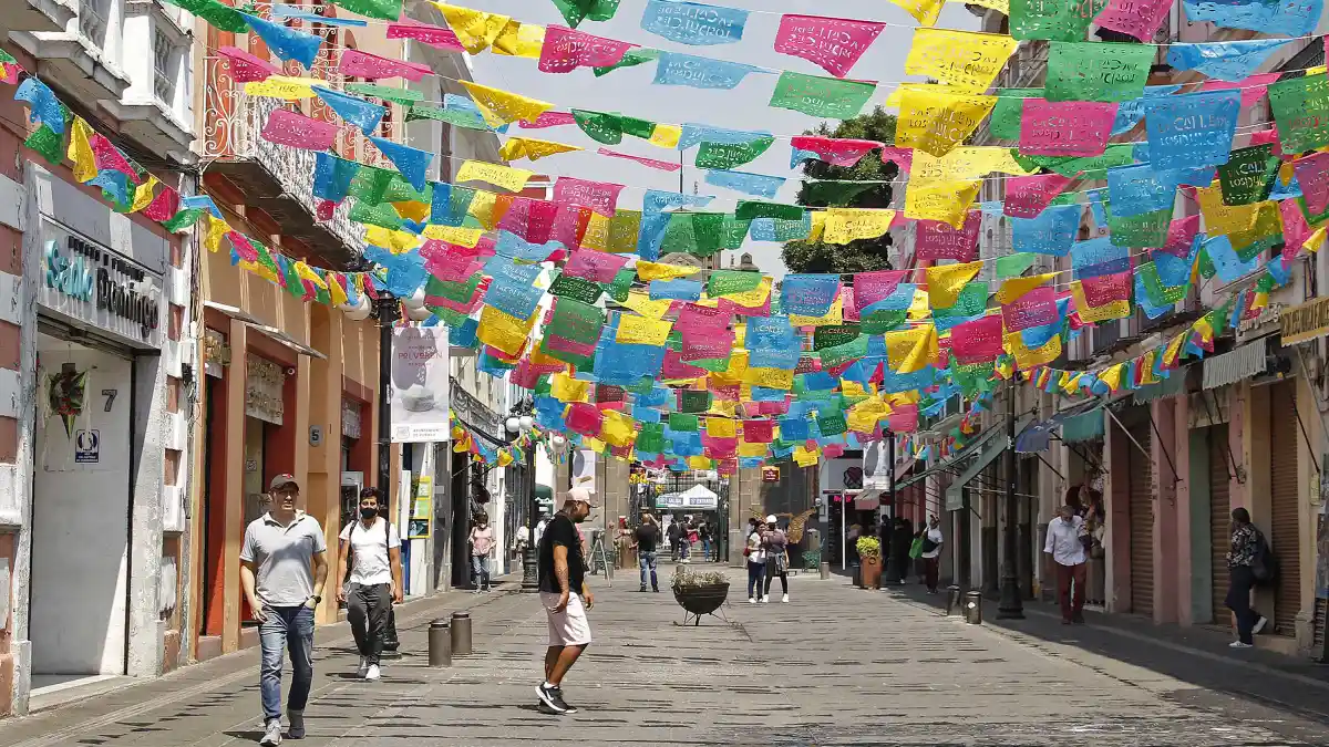 Personas caminando sobre la calle de los dulces de Puebla.