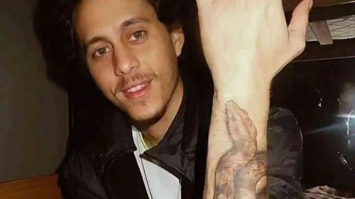 El rapero Canserbero mostrando un tatuaje de una serpiente en uno de sus brazos.