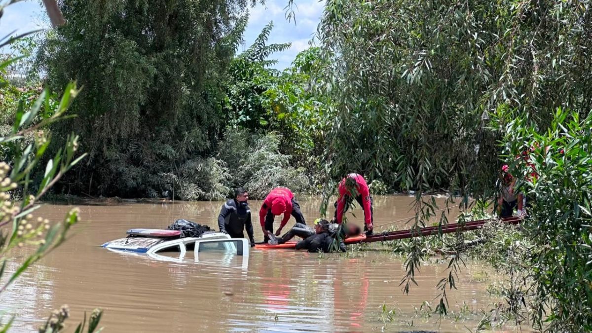 Rescatistas sacan los cuerpos de tres mujeres hallados en la patrulla arrastrada por el río Atoyac en Santa Clara Ocoyucan